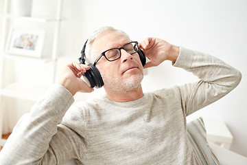 Image showing happy man in headphones listening to music at home