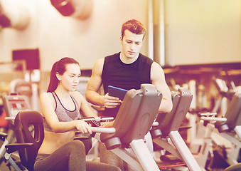 Image showing woman with trainer on exercise bike in gym