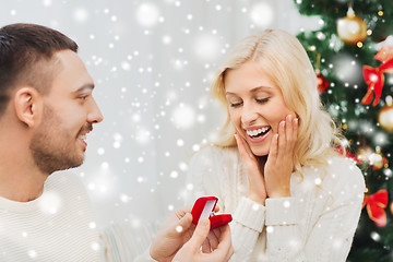 Image showing man giving woman engagement ring for christmas