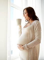 Image showing happy pregnant woman with cup drinking tea at home