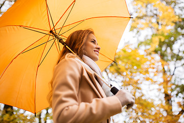 Image showing happy woman with umbrella walking in autumn park