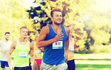 Image showing happy young sportsmen racing wit badge numbers