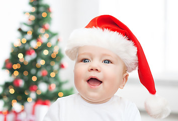 Image showing baby boy in christmas santa hat over blue lights