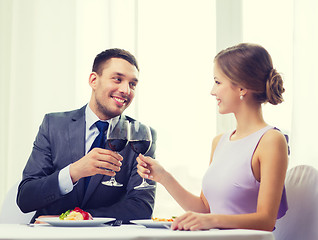Image showing couple with main course and red wine at restaurant