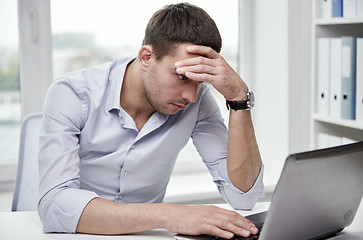 Image showing stressed businessman with laptop at office