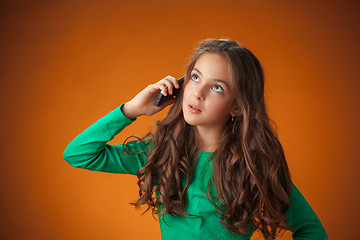 Image showing The cute cheerful little girl on orange background