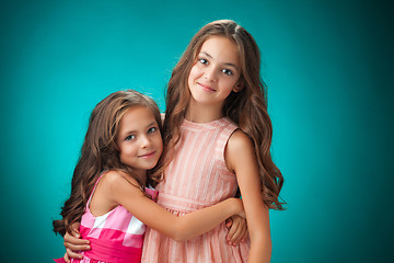 Image showing The two cheerful little girls on orange background