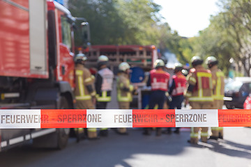 Image showing Team of firefighters by firetruck on accident location.