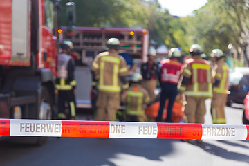 Image showing Team of firefighters by firetruck on accident location.