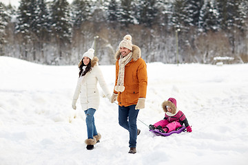 Image showing happy family with sled walking in winter forest