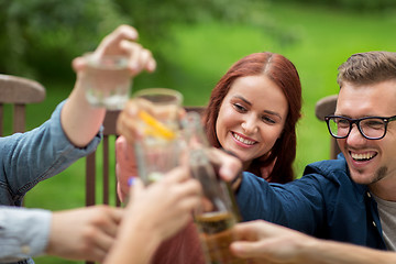 Image showing happy friends clinking glasses at summer garden