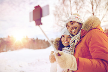 Image showing happy couple taking selfie by smartphone in winter