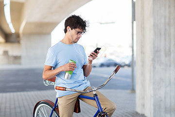 Image showing man with smartphone and earphones on bicycle