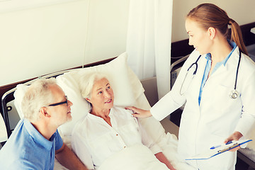 Image showing senior woman and doctor with clipboard at hospital