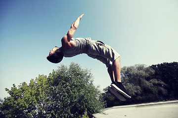 Image showing sporty young man jumping in summer park