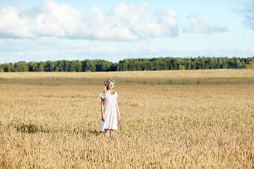 Image showing happy young woman in flower wreath on cereal field