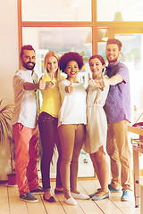 Image showing happy creative team showing thumbs up in office