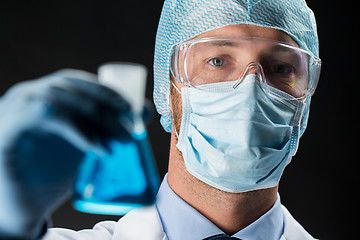 Image showing close up of scientist holding flask with chemical