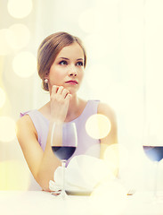 Image showing upset woman with glass of whine waiting for date