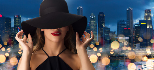 Image showing beautiful woman in black hat over singapore city