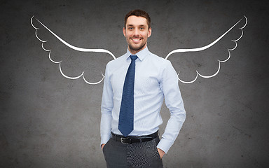 Image showing happy businessman with angel wings over gray