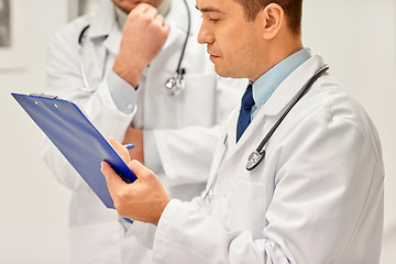 Image showing close up of doctors with clipboard at hospital