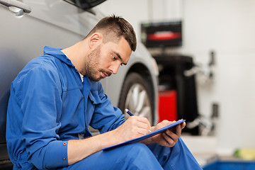 Image showing auto mechanic man with clipboard at car workshop