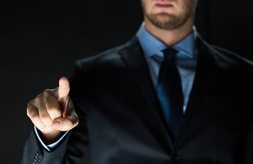 Image showing close up of businessman touching virtual screen