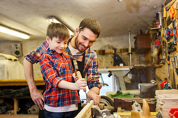 Image showing father and son with chisel working at workshop