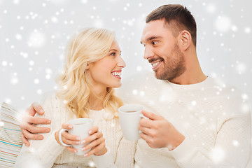 Image showing happy couple with cups drinking tea at home