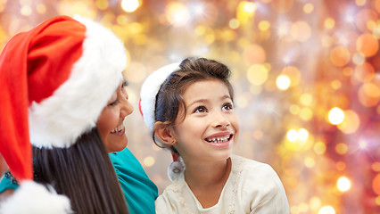 Image showing happy mother and little girl in santa hats