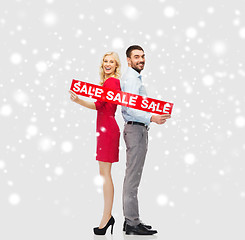 Image showing happy couple with red sale sign over snow