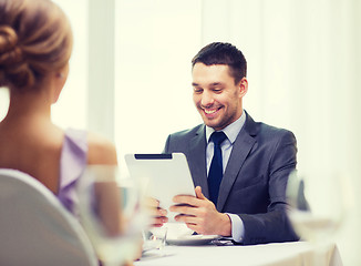 Image showing smiling man looking at menu on tablet pc computer