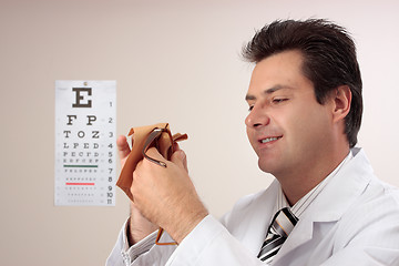 Image showing Optometrist cleaning glasses