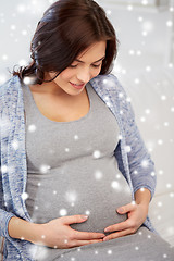 Image showing happy pregnant woman sitting on sofa at home