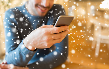 Image showing close up of man with smartphones at cafe