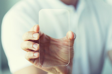 Image showing close up of male hand with transparent smartphone