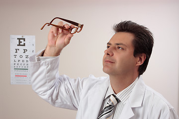 Image showing Optometrist inspecting eye glasses