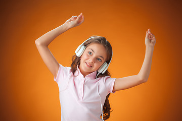 Image showing The cute cheerful little girl on orange background