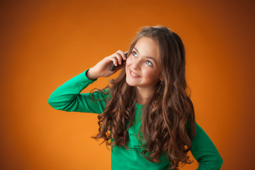 Image showing The cute cheerful little girl on orange background