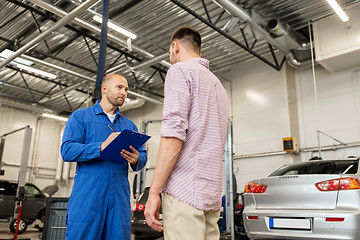 Image showing auto mechanic with clipboard and man at car shop