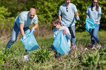 Image showing volunteers with garbage bags cleaning park area