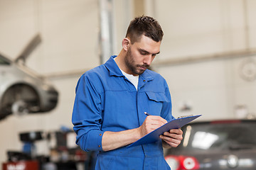 Image showing auto mechanic man with clipboard at car workshop