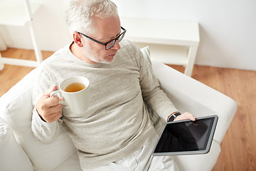 Image showing senior man with tablet pc and tea cup at home