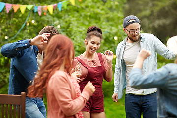 Image showing happy friends dancing at summer party in garden