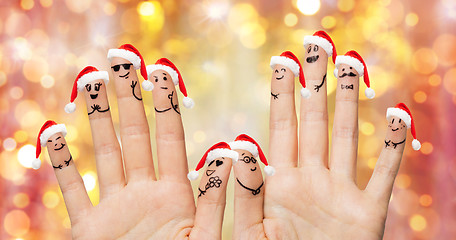 Image showing close up of fingers with smiley in santa hats