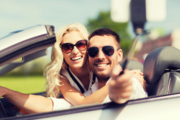 Image showing happy couple in car taking selfie with smartphone