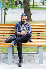 Image showing man writing to notebook or diary on city street