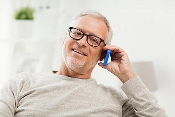 Image showing happy senior man calling on smartphone at home