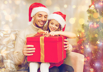 Image showing smiling father and daughter opening gift box